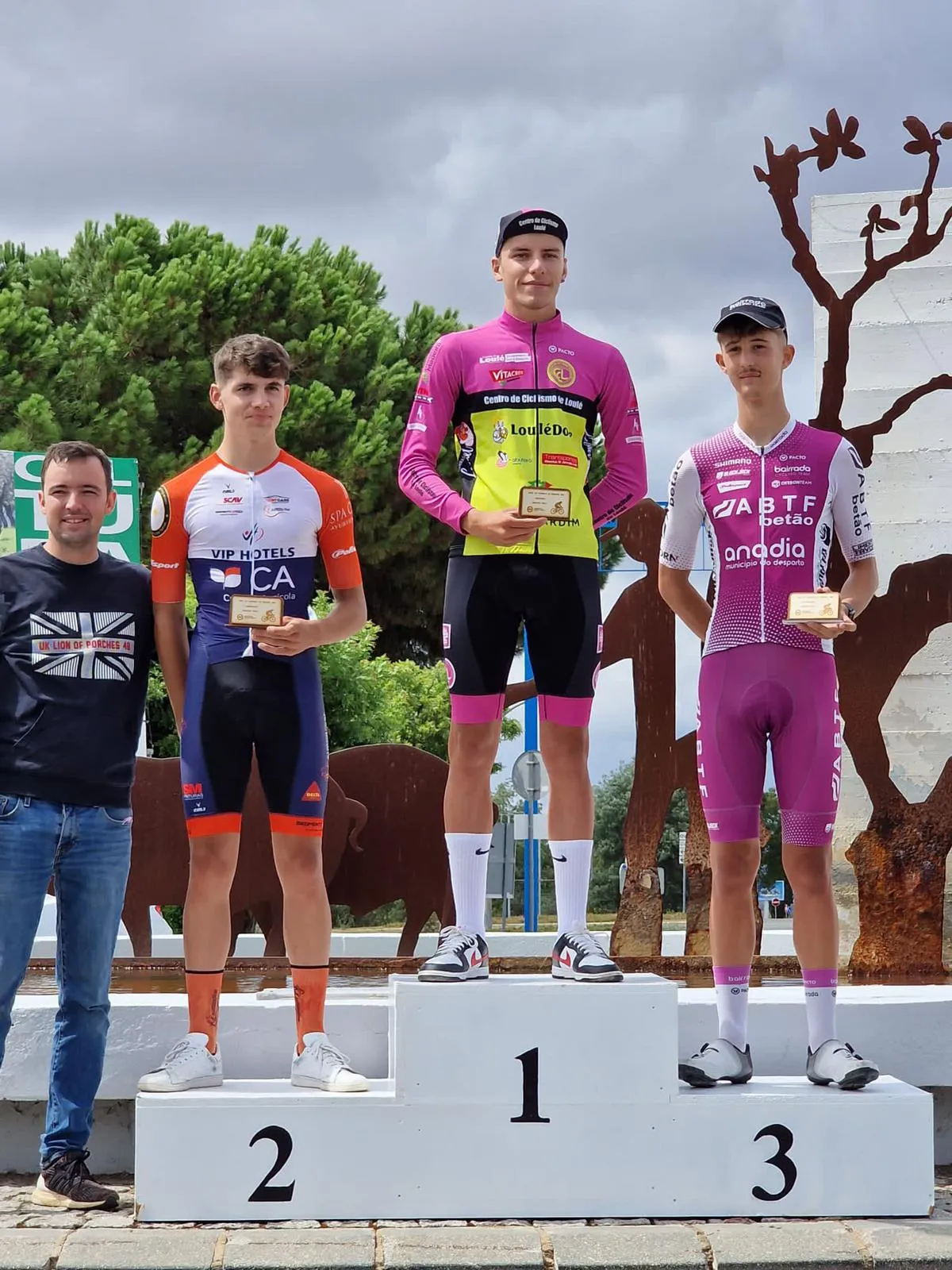An athlete coached by Lopes Performance on the top step of a road race podium